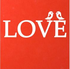 two birds sitting on top of a red book with the word love written in white