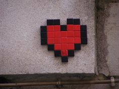 a red and black heart shaped tile on the side of a building