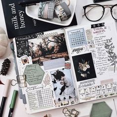 the contents of a planner spread out on a table with pens, eyeglasses and other items