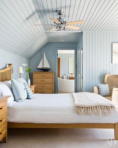 a bed room with a neatly made bed and a ceiling fan in the middle of it