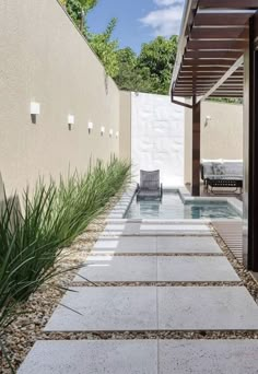 an outdoor area with a pool, patio and pergolated walkway leading up to the house