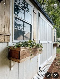 a window on the side of a house with plants growing in it's windowsill