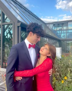 a man in a tuxedo and woman in a red dress