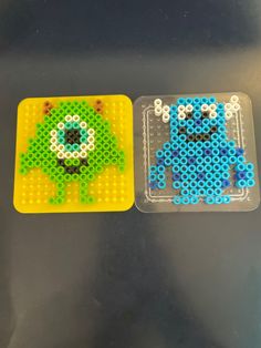 two plastic trays with different colored beads on them, one has an animal and the other has a monster