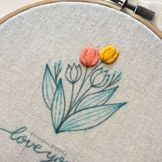 two flowers are sitting on top of the embroidery