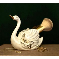 a white swan figurine sitting on top of a table next to a necklace