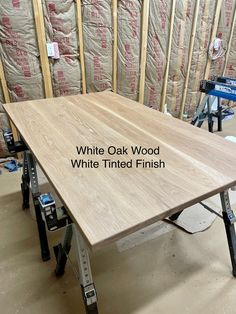 a white oak table with the words white tinted finish on it in front of some construction materials