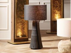 a table lamp sitting on top of a hard wood floor next to a wooden cabinet