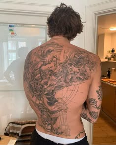 the back of a man with tattoos on his body