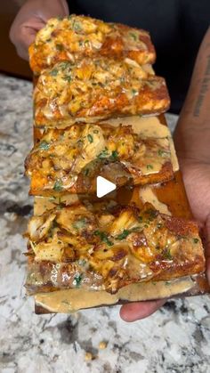 someone holding up some pizza slices with cheese and sauce on them in front of the camera