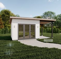 a small white shed sitting on top of a lush green field