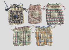 four crocheted purses hanging from strings on a gray background, each with a different pattern