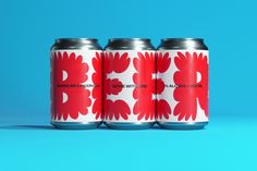 three red and white cans with flowers on them