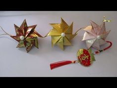 three origami ornaments with tassels on them