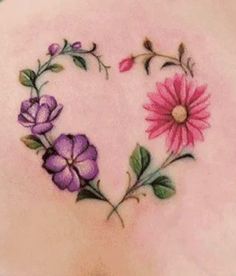 a woman's back with flowers in the shape of a heart on her stomach