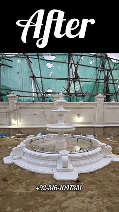 a large white fountain sitting in the middle of a building under construction with text overlaying it