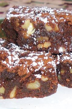 several pieces of brownie on a plate covered in powdered sugar