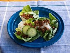 a blue plate topped with lettuce and cucumber slices on top of it