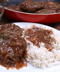 a white plate topped with rice and meat covered in gravy