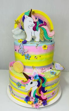 a three tiered cake decorated with an image of a unicorn