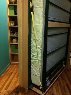 the bottom half of a storage unit in a room with hard wood flooring and green walls