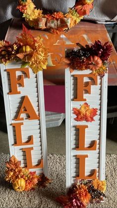 two wooden letters decorated with fall leaves