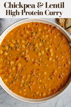 chickpea and lentil high protein curry in a white bowl with crackers on the side