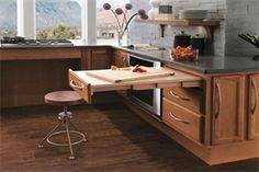 a kitchen with wooden cabinets and black counter tops, along with an island in the middle