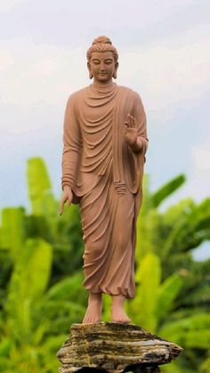 a buddha statue sitting on top of a wooden stump