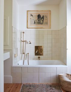 a bathroom with a bathtub, rug and pictures on the wall above it is shown