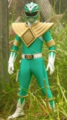 a man in green and yellow costume standing next to tall grass