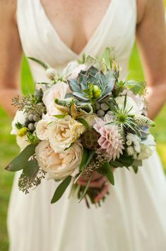 a bridal holding a bouquet of flowers and greenery