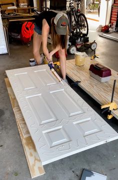 two women working on an unfinished door in a garage