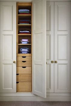 an open closet with drawers and clothes in it