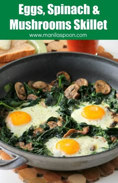 two fried eggs and spinach in a skillet on a cutting board with bread