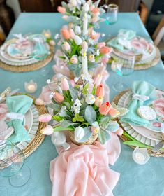 a table set with plates, napkins and flowers