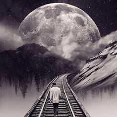 a man walking on train tracks towards the moon