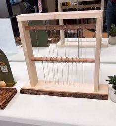 an old weaving machine is on display in a room with other items and plants around it