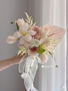 a person holding a bouquet of flowers in their hand