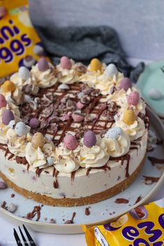 there is a cake on the table with chocolate eggs and marshmallows around it