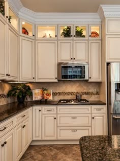 a kitchen with white cabinets and granite counter tops