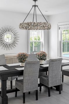 a dining room table with chairs and a chandelier hanging from it's ceiling