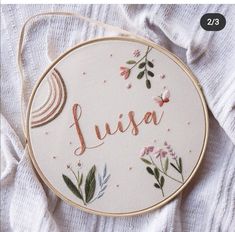 a cross stitch pattern with the word julia in cursive writing and flowers on it