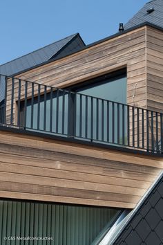 a wooden building with metal balconies and windows