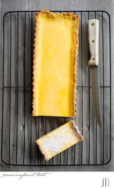 there is a piece of cheese and a knife next to it on a rack with wire