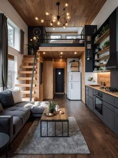 a living room filled with furniture next to a kitchen and dining area in a loft