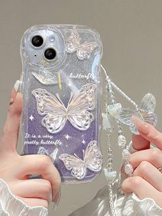 a woman holding up a phone case with butterflies on it