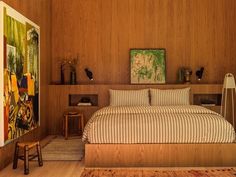 a bedroom with wood paneling and artwork on the wall