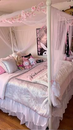 a white canopy bed with pink pillows and teddy bears