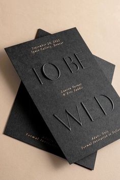 two black business cards with gold foil on them